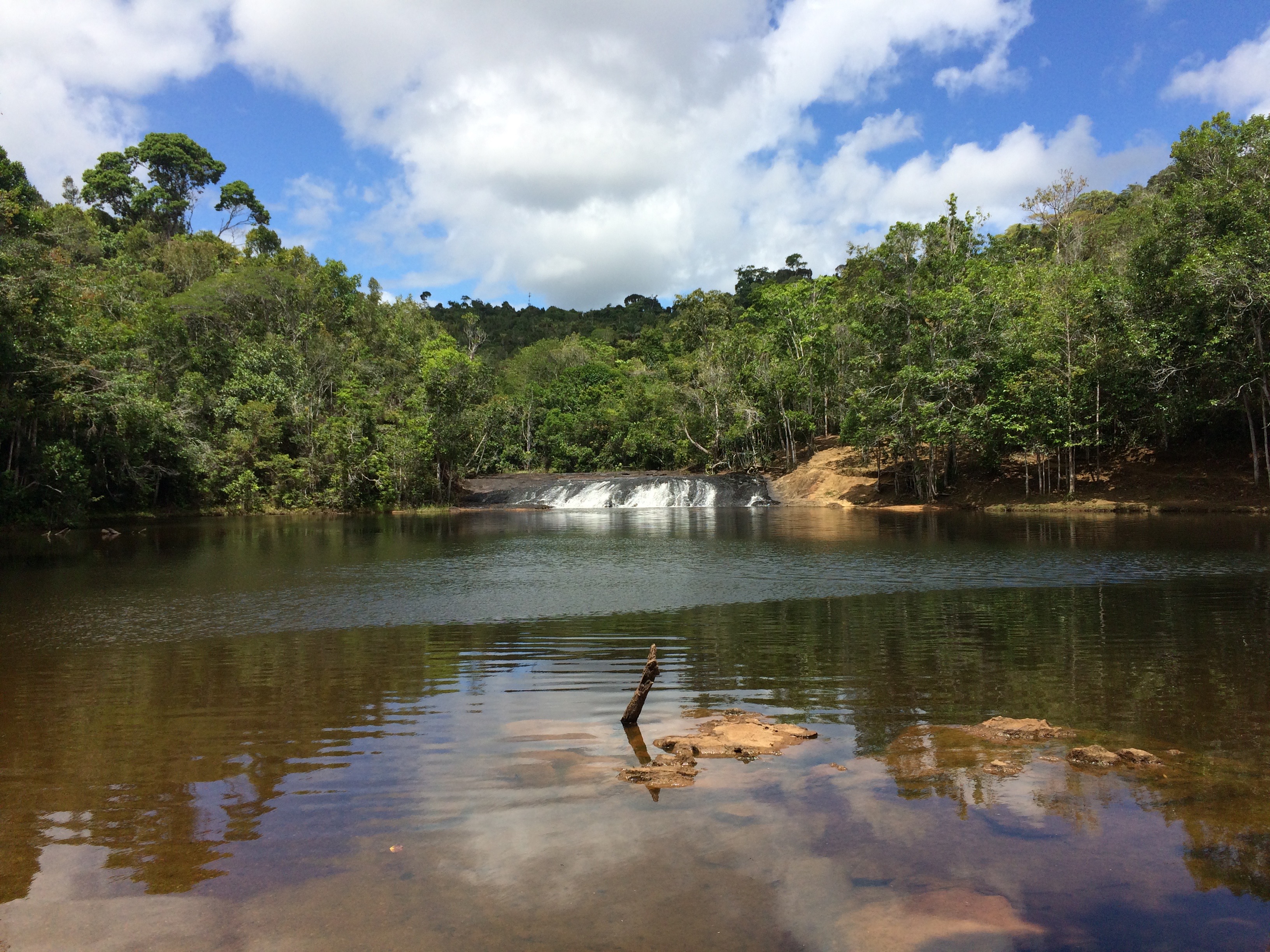 Queda d’água e piscina natural cercadas pela vegetação na região de Tijuípe, Bahia