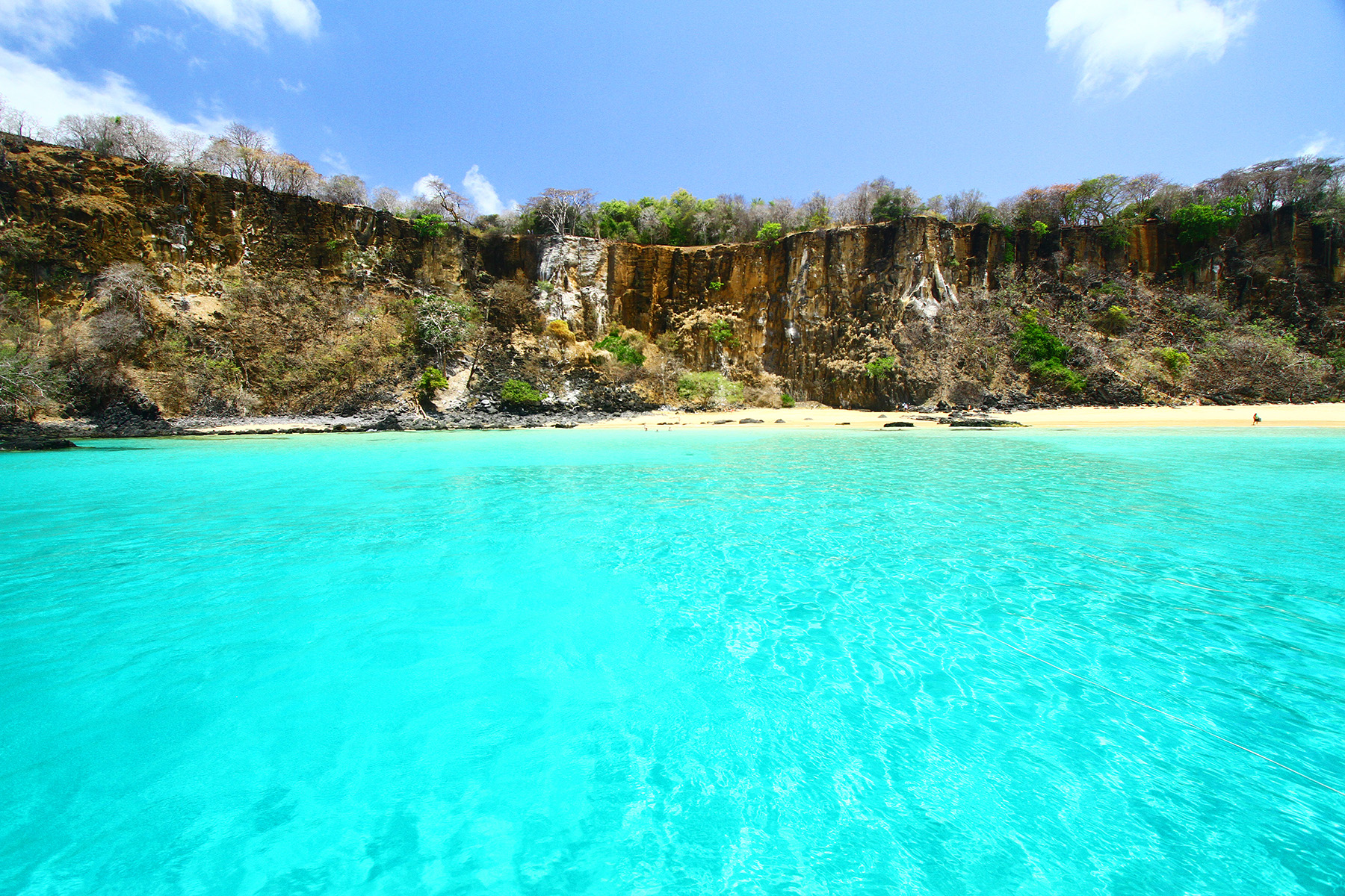 Vista da Baía do Sancho com mar transparente e falésias em Fernando de Noronha