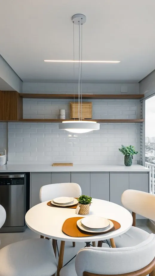 Cozinha compacta com mesa redonda e armários sob medida