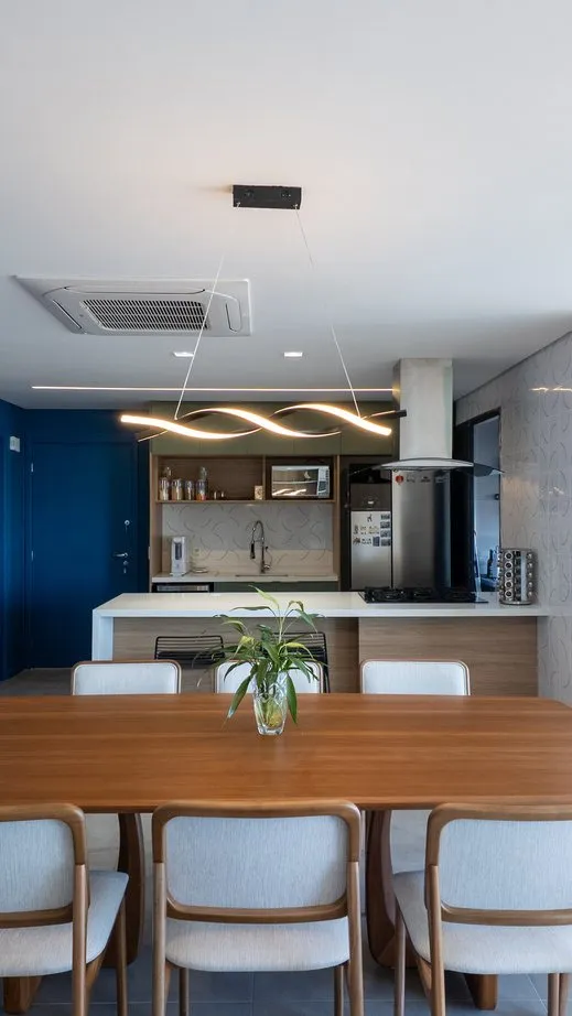 Sala de jantar integrada à cozinha com marcenaria e iluminação planejada
